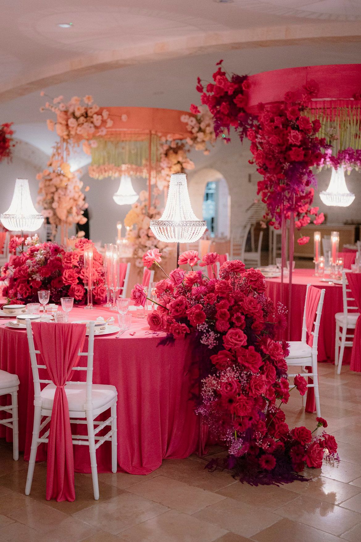 Vista panoramica allestimento LIPPOLIS: sala matrimoniale con mix peach e fucsia, chandelier multipli